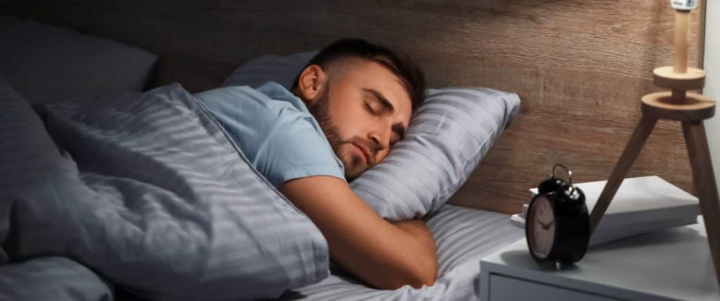 Young man sleeping in bed at night